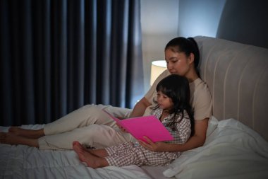 Anne, kitaptaki küçük kız için geceleri yatakta masal okurdu.