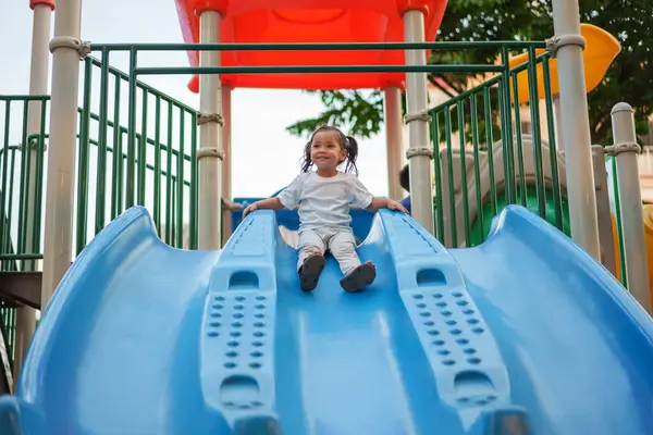 # Mutlu bebek kız bebek parkta kayıyor ve oynuyor #