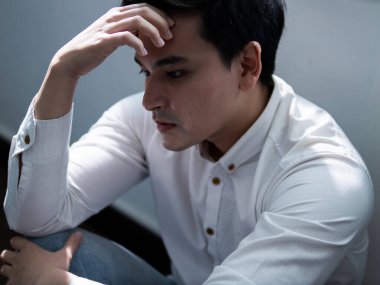 Düşüncelere dalmış düşünceli bir adam. Duygusal portre hazırlıyor. Yakın plan aydınlatma, zihinsel sağlık yansıması.