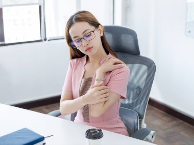 Modern çalışma ortamından rahatsız olan ofis çalışanı. Profesyonel çevre, ergonomik sağlık sorunlarına odaklanıyor.