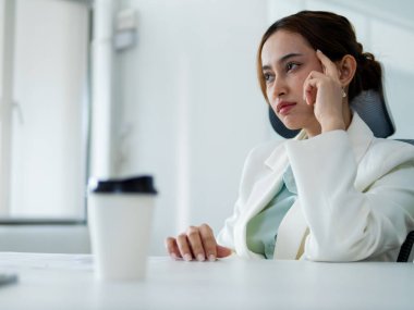 Modern ofis profesyonel portresindeki düşünceli iş kadını kapalı mekan görüşünü odaklıyor.