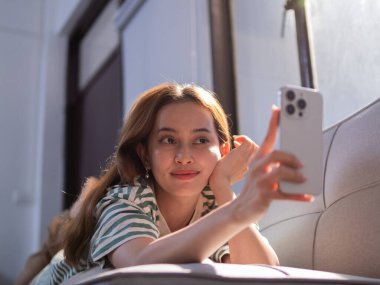 Akıllı telefon kullanarak rahatlatıcı kadın modern apartman tarzı imaj konforlu çevre yakın çekim dijital bağlantı