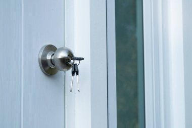 Yeni başlangıçların anahtarlarını kapı kilidinde açmak ev girişini kilitlemek.