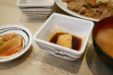 Japon mutfağı deneyimi, restoran iç yemek sunumu, gündelik yemek, yakın çekim mutfak kültürü.