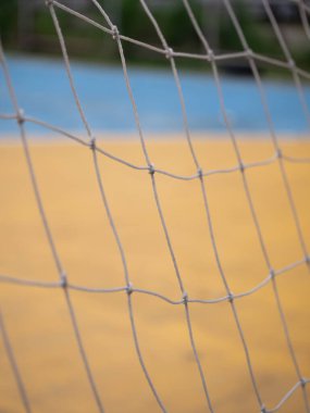 Açık hava fotoğrafçılık dinamik perspektif atletizm için sarı kortta bir ağın yakın çekimi.