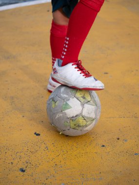 Futbolcu, top kentsel oyun alanı spor aksiyonu dengesi kuruyor. Renkli çevre dinamik bakış açısı, atletik beceri gösterisi.