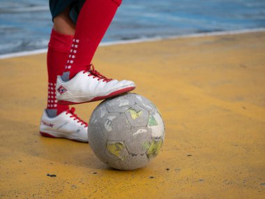 Futbolcu, şehir dışında oynanan bir oyun parkında dengede duruyor. Yakın çekim atletik yetenek gelişimi.