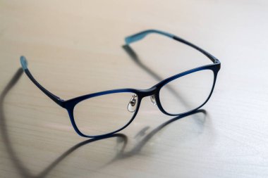 Moda fotoğrafçılığının ahşap masa üzerindeki şık gözlüklerin yakın çekimi.