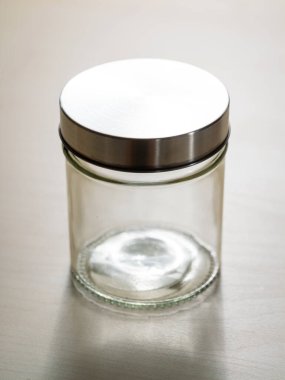 Minimalist cam kavanoz ve metal kapaklı mutfak depolama konsepti.