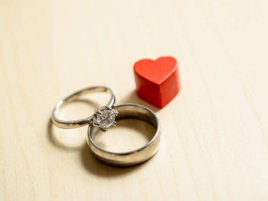 Nişan kutlaması için kalp sembollü romantik alyansların yakın plan çekimi.