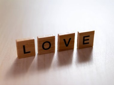 Bu resim, aşkın özünü ahşap harflerle yazılmış minimalist bir iç mekanda yakalıyor.