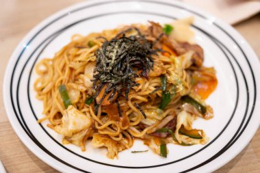 Taze sebzelerle süslenmiş canlı kızarmış eriştenin tadını çıkarın. Mutfak sanatını sergileyin..