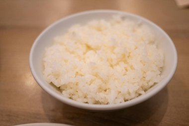 Sıcak bir Japon restoranında servis edilen ve aşçılık geleneğini ön plana çıkaran bir kase beyaz pirinç..