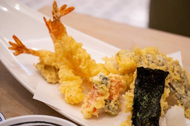 Sıcak bir Japon restoranında sunulan gevrek tempura karides ve sebze çeşitleri..