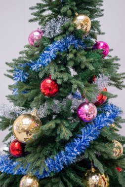 Güzel dekore edilmiş bir Noel ağacı. Kapalı bir ortamda canlı süsler sergiliyor..