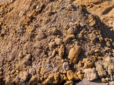 Bu resim, kazı tekniklerini vurgulayan bir inşaat sahasındaki toprak yığınının yakın görüntüsünü gösterir..