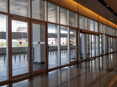 Cam kapılar ve modern tasarım elementlerinin yer aldığı gösterişli bir mimari alan keşfedin..