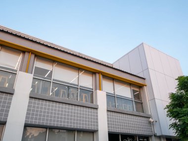 Çağdaş mimari tasarımı resmeden temiz bir gökyüzüne karşı modern bir bina cephesi gösteriliyor.