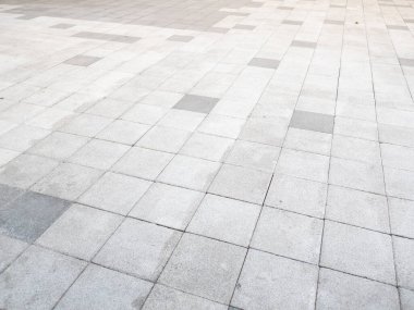 Şehir meydanındaki dokulu gri kaldırım taşlarına detaylı bir bakış. Şehir hayatının özünü yansıtıyor..