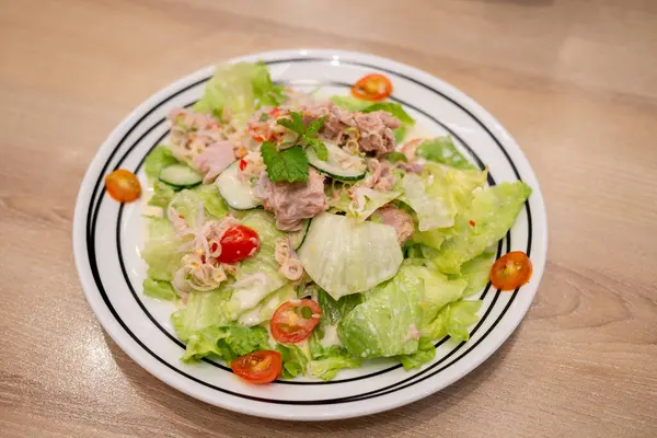 Taze malzemelerle yapılmış canlı bir ton balığı salatasının tadını çıkarın. Sağlıklı bir yemek için mükemmel..