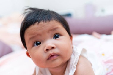 Yeni doğmuş meraklı bir Asyalı bebek masum bir şekilde ev hayatının sıcaklığını yakalıyor..