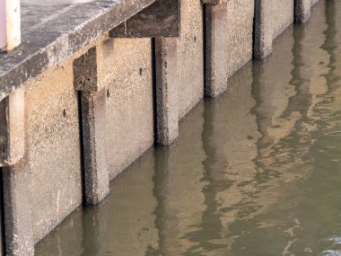 Bir rıhtımın sakin su üzerindeki yapısının sakin bir yansıması kentsel sükuneti gösteriyor..