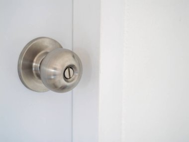 Pürüzsüz bir kapı tokmağının, dizaynını ve dokusunu minimalist bir ev ortamında yakaladığı yakın çekim..