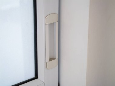 Çağdaş bir evde modern bir pencere tutacağının yakın çekim görüntüsü gösterişli parlak tasarım ve minimalist estetik.