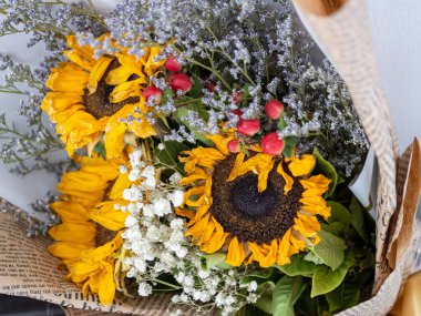 Ayçiçekleri ve kurumuş çiçeklerle dolu canlı bir buket. Her yeri aydınlatmak için mükemmel..