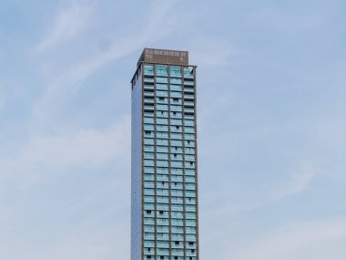 Çarpıcı bir modern gökdelen canlı bir şehir manzarasının ortasında yenilikçi bir mimari tasarım sergiliyor..