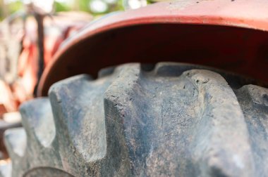 Bir traktör lastiğinin yakın plan görüntüsü çiftçilik işi için gerekli olan sert dokuyu ve dayanıklılığı sergiler..