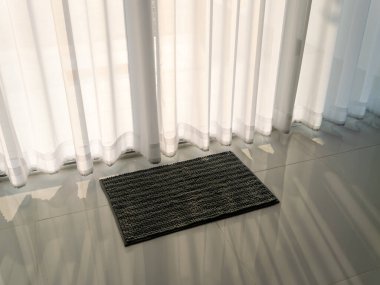 Sabah ışığı, modern bir evde perdeleri dikerek rahat bir paspası aydınlatır.