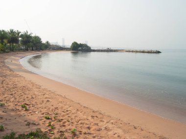 Sakin bir sahil sahnesi, sakin dalgaları ve yumuşak kumları yakalar ve sahil boyunca huzurlu yürüyüşleri davet eder..