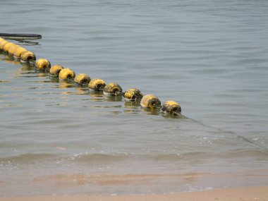 Şamandıralar, sakin kıyı manzarasını güzelleştirirken güvenli bir şekilde kıyıya yakın yüzerler..