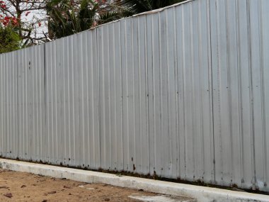 Basit ama etkili bir metal çit, güvenlik ve mahremiyeti vurgulayan sakin bir kentsel alan tanımlar..