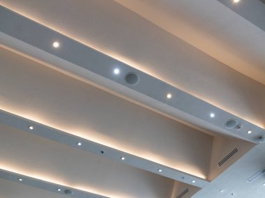 Modern aydınlatma ve mimari zarafeti vurgulayan çağdaş ofis tavanının parlak tasarımını keşfedin.