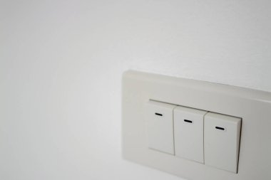 A close-up shot of a modern light switch panel in a minimalist home interior.