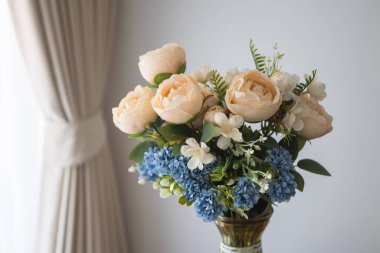 A stunning close-up of peony and blue flowers in a vase capturing serene beauty.