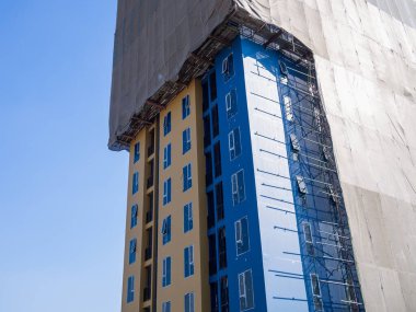 Devam eden binanın yenilenmesini canlı renkler sergiliyor ve hareketli bir şehir ortamını inşa ediyor..