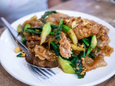 Canlı bir tabak kızarmış tavuk ve yeşillikler yerel mutfağı ön plana çıkarıyor..