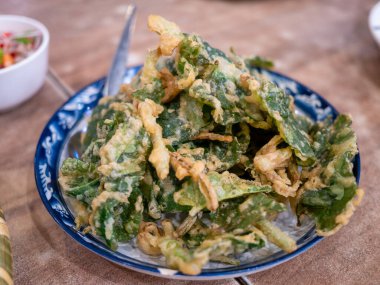 Bir tabak kızarmış sebze yerel mutfağın özünü yakalıyor. Hareketli bir pazar..