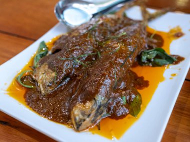 Köri balığının zengin lezzetlerinin tadını çıkarın canlı bir kıyı restoranına servis edilen mutfak sanatını sergileyin..