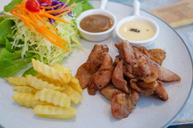 Canlı bir tabak kızarmış tavuk taze salata ve soslar mutfak sanatını gözler önüne seriyor..