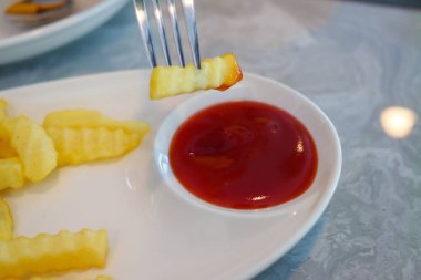 Kızarmış patateslerin ve zengin ketçapın keyfini çıkarıyorum..