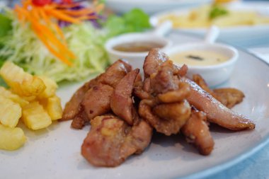 Taze sebze ve sosla servis edilen ızgara tavuğun tadını çıkarın..