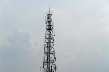 Çarpıcı bir telekomünikasyon kulesi şehir bağlantısını simgeleyen bulutlu bir gökyüzüne yükseliyor.