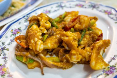 Yerel gözde bir restoranda sunulan baharatlı deniz ürünleri tabağı canlı aromalar ve dokular sunuyor..