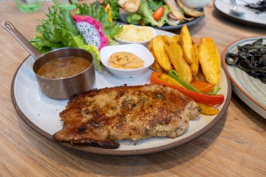 Konforlu bir restoranda, rengarenk ve ızgara tavukların sergilendiği canlı bir yemek..