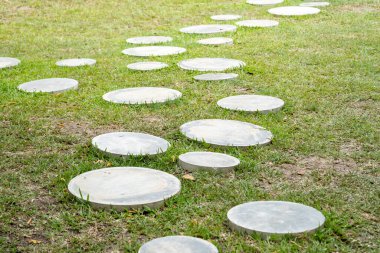 Yuvarlak taşlarla yaratılmış sakin bir bahçe yolu sükuneti ve doğal güzelliği davet ediyor..