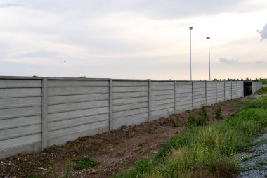Şehir gelişimini simgeleyen beton bariyer, akşam gökyüzüne karşı dimdik ayakta duruyor..